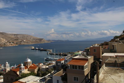 High angle view of town by sea against sky