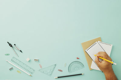 High angle view of hand holding paper against white background