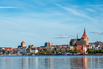 River by buildings against blue sky