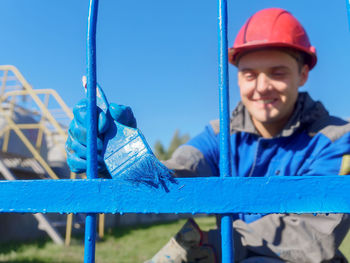 Portrait of young man standing by railing