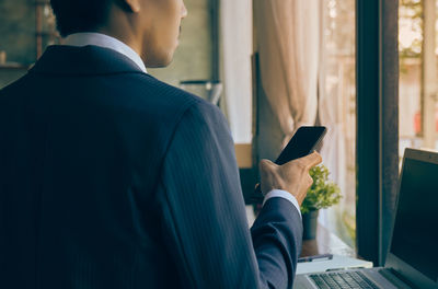 Midsection of man using mobile phone