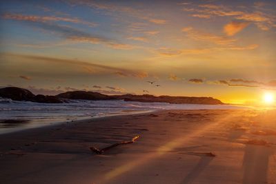 Scenic view of beach against sky during sunset