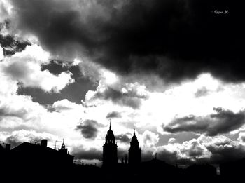 Low angle view of silhouette building against cloudy sky