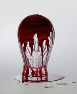 Close-up of red glass over white background