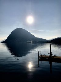 Wooden posts in lake against sky