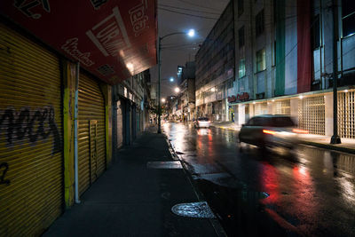View of street amidst buildings at night