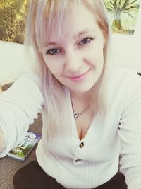 Portrait of smiling young woman sitting outdoors