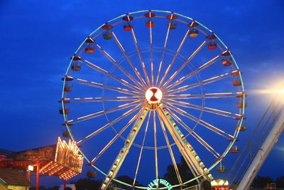 Low angle view of illuminated ferris wheel against sky