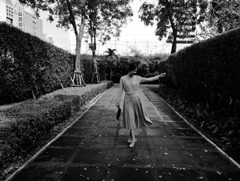 Rear view of woman walking on zebra crossing