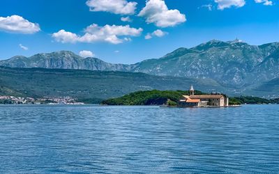 Scenic view of sea by buildings against sky