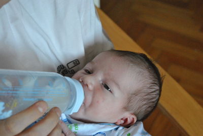 Close-up of mother feeding baby at home