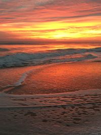 Scenic view of sea against dramatic sky during sunset