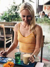 Young woman sitting on chair at cafe