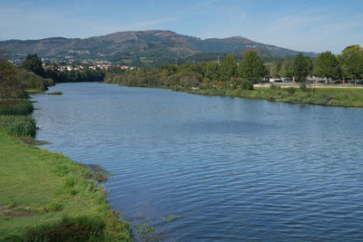 Scenic view of lake by mountains against sky