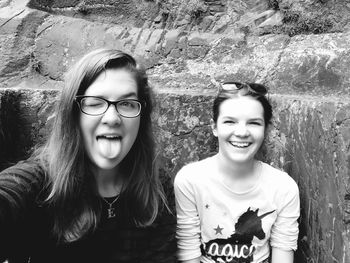 Portrait of smiling friends with friend against rock formations