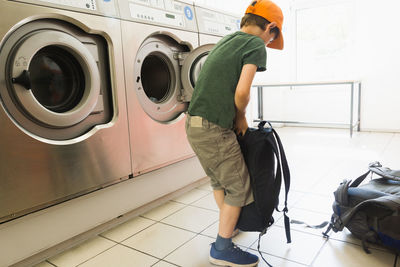 Boy carrying backpack in room