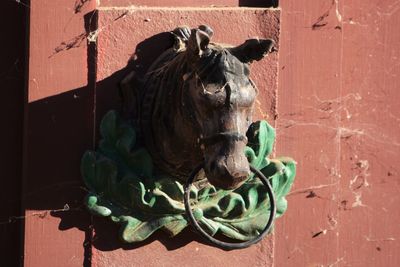 Close-up of hitching ring on horse sculpture on door