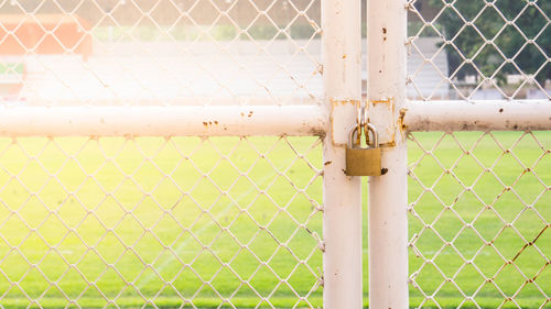 Close-up of metal fence with closed gate