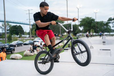 Young man riding bicycle on city