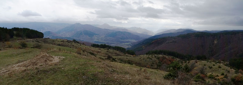 Scenic view of mountains against cloudy sky