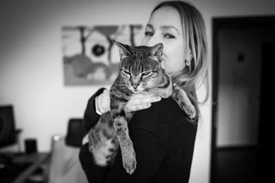 Woman holding cat at home