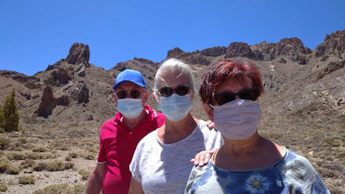 Portrait of smiling people standing against sky