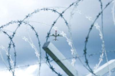 Low angle view of barbed wire against sky