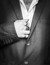 Close-up midsection of man wearing blazer and rings