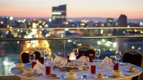 View of wine glass on table against cityscape at sunset