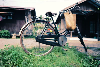 Bicycle parked outside house on field