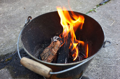 Do it yourself backyard bbq grill in a bucket with sausages and potatoes