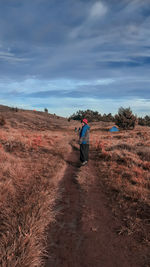 Full length of woman standing on land against sky