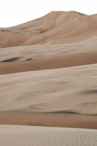 Sand dunes in desert against sky