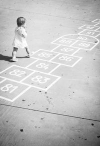 High angle view of girl playing on footpath