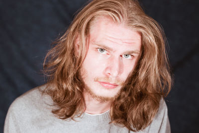 Close-up portrait of young man with long hair