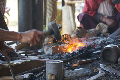 Cropped image of blacksmith working by fire