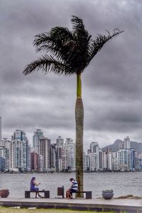 Skyscrapers in city against cloudy sky