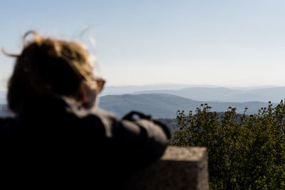 Rear view of man looking at mountain against sky