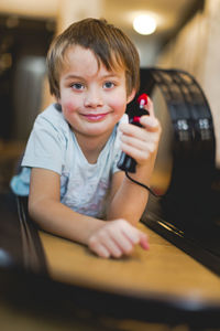 Portrait of boy lying down amidst toy racetrack