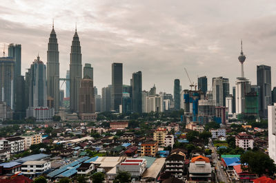 Modern buildings in city against cloudy sky