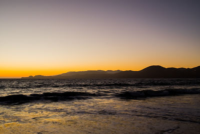 Scenic view of sea against clear sky during sunset