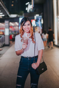 Portrait of smiling young woman standing outdoors