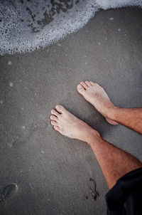 Low section of person on sand at beach