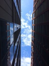 Low angle view of modern buildings against cloudy sky