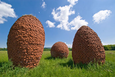 Hay bales on field against sky