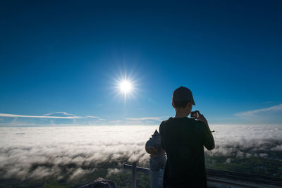 Man photographing against sky during winter