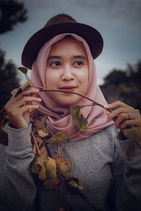 Close-up of woman wearing hat looking away