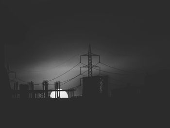 Silhouette electricity pylon against sky