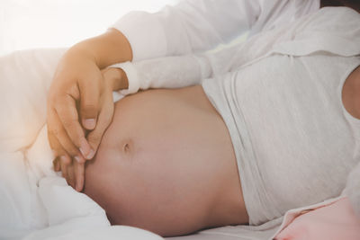 Midsection of baby sleeping in bed