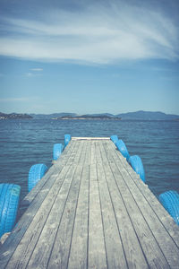 Wooden pier over sea against sky